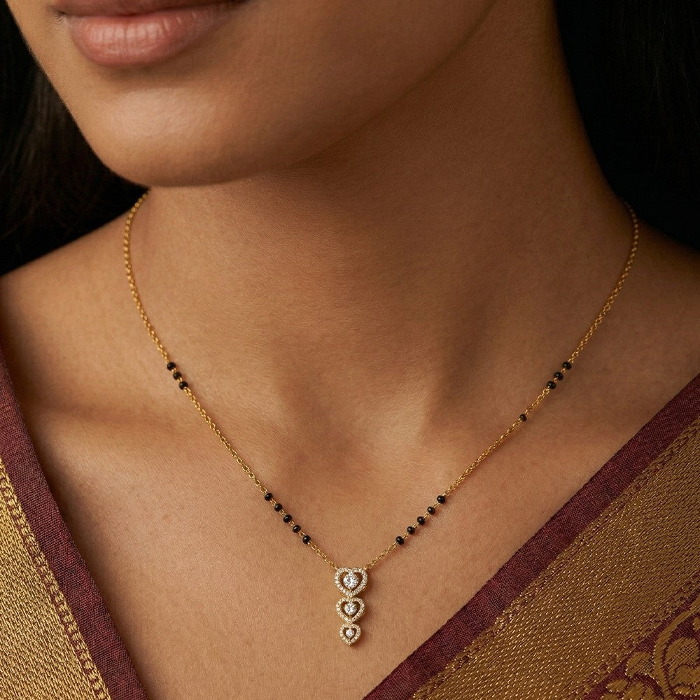 Close-up of a woman wearing a gold mangalsutra with a pendant.
