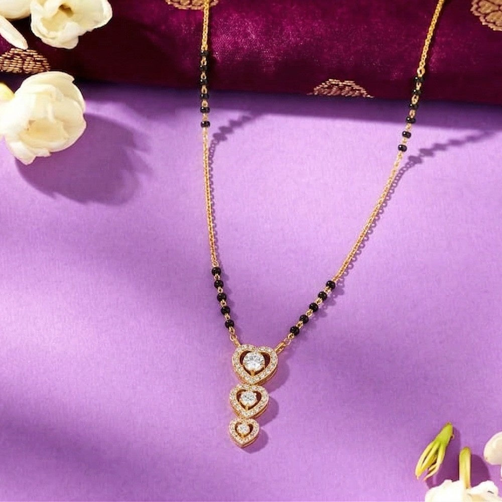 Gold mangalsutra with heart-shaped on a purple fabric background