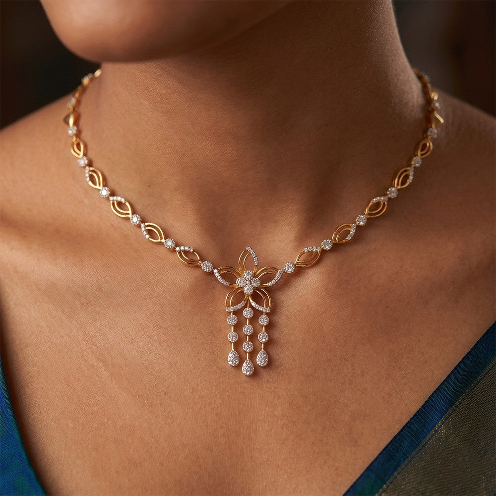 A close-up of a woman wearing a gold and diamond necklace with a central floral.