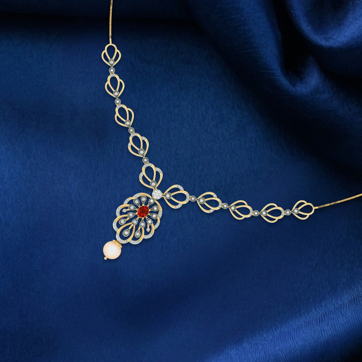 Gold and diamond necklace with a central floral motif featuring a red gemstones, displayed on a draped dark blue satin fabric.