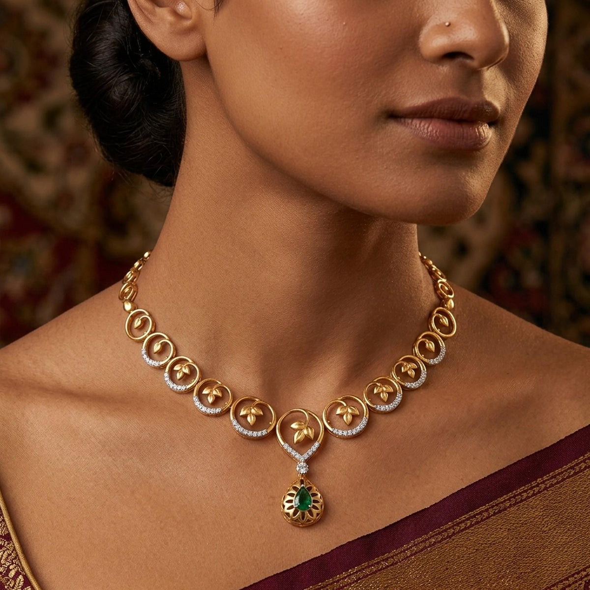 A close-up lifestyle shot of a model wearing a gold and diamond necklace set with a green gemstone.