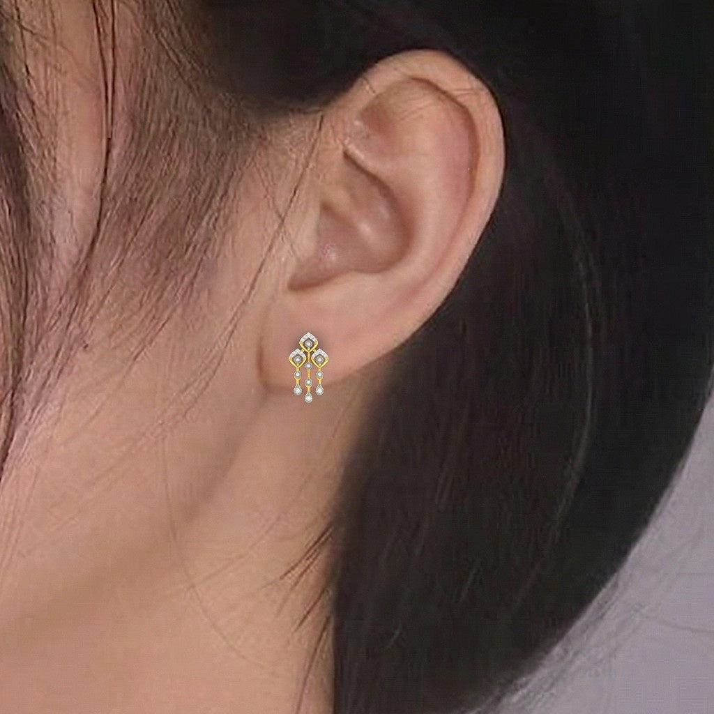 A close-up of a person's ear wearing a drop earring with a floral and three dangling pearl-like beads.