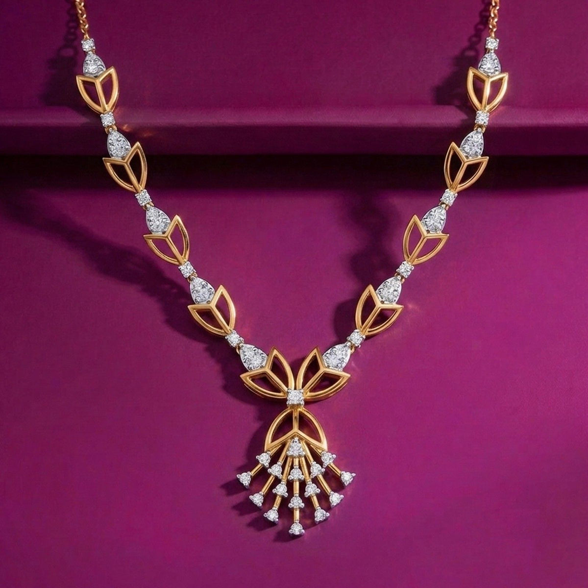 A gold and diamond necklace displayed on a deep magenta background. 