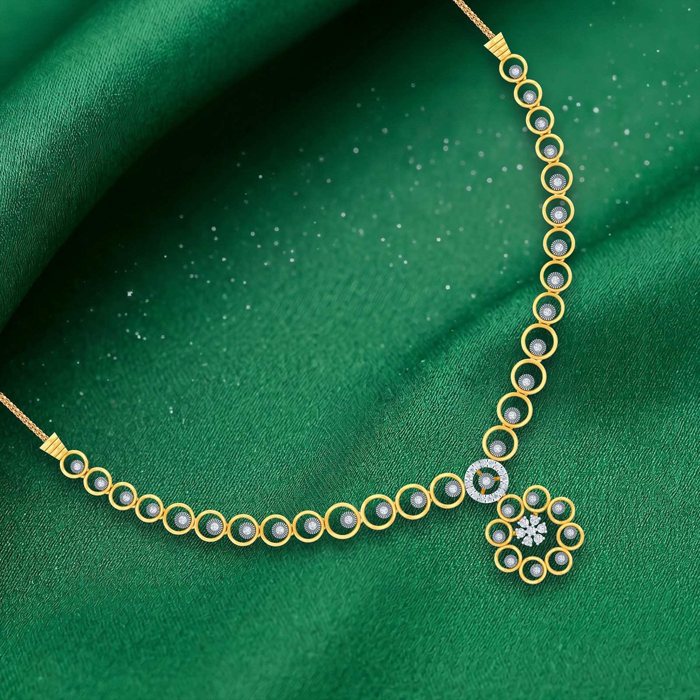 A gold and diamond necklace with circular design, displayed on a textured green fabric background.