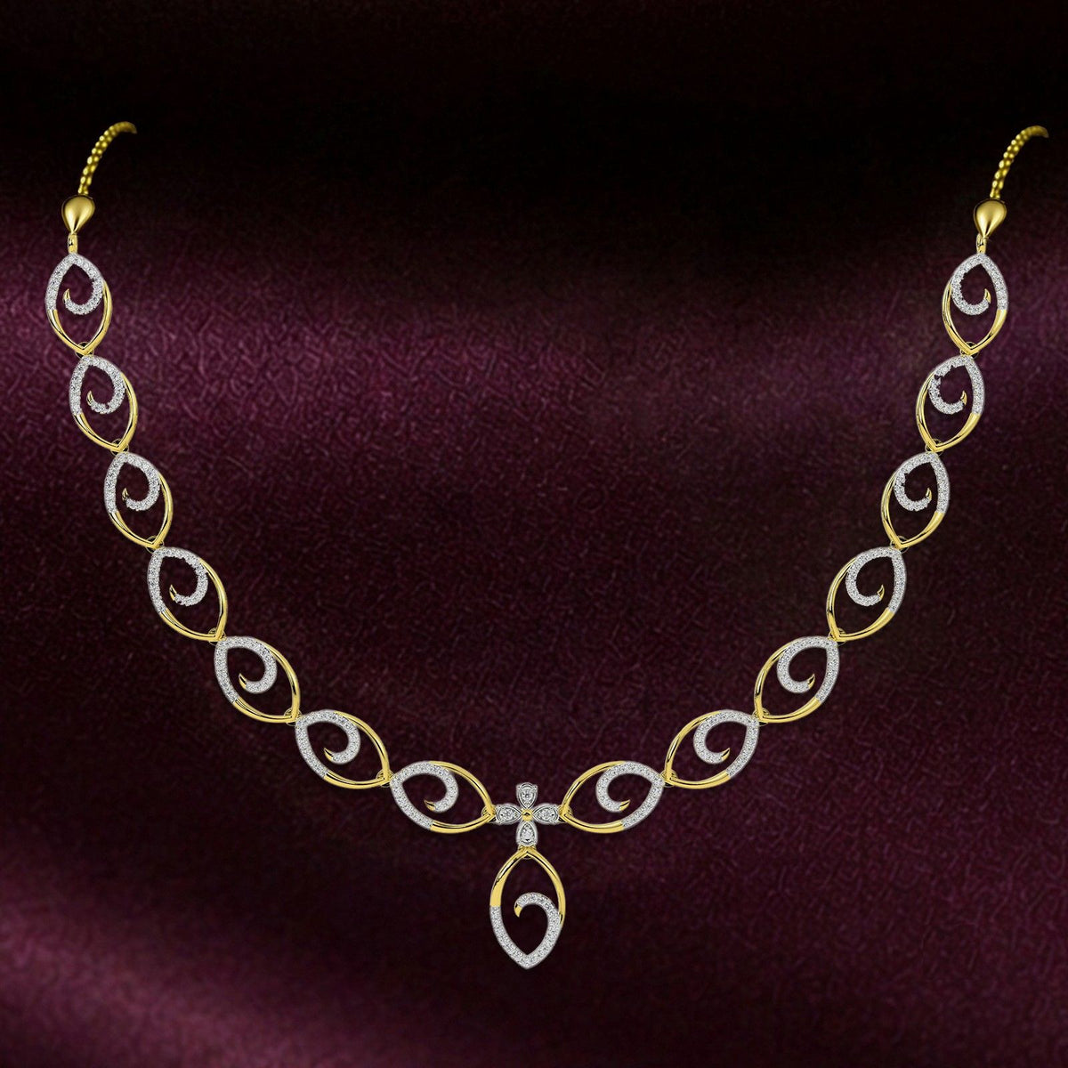Gold and diamond necklace with a central teardrop pendant, displayed on a dark burgundy satin background.