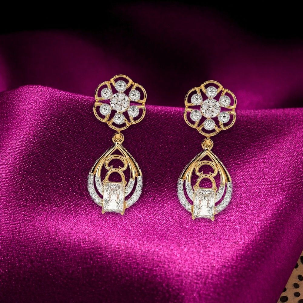 A pair of gold and diamond dangler earrings, displayed on a rich magenta satin fabric background.