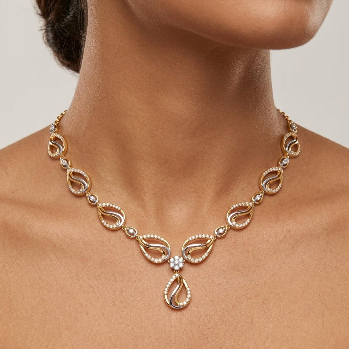 A close-up of a model's neck wearing a gold and diamond necklace with a teardrop.