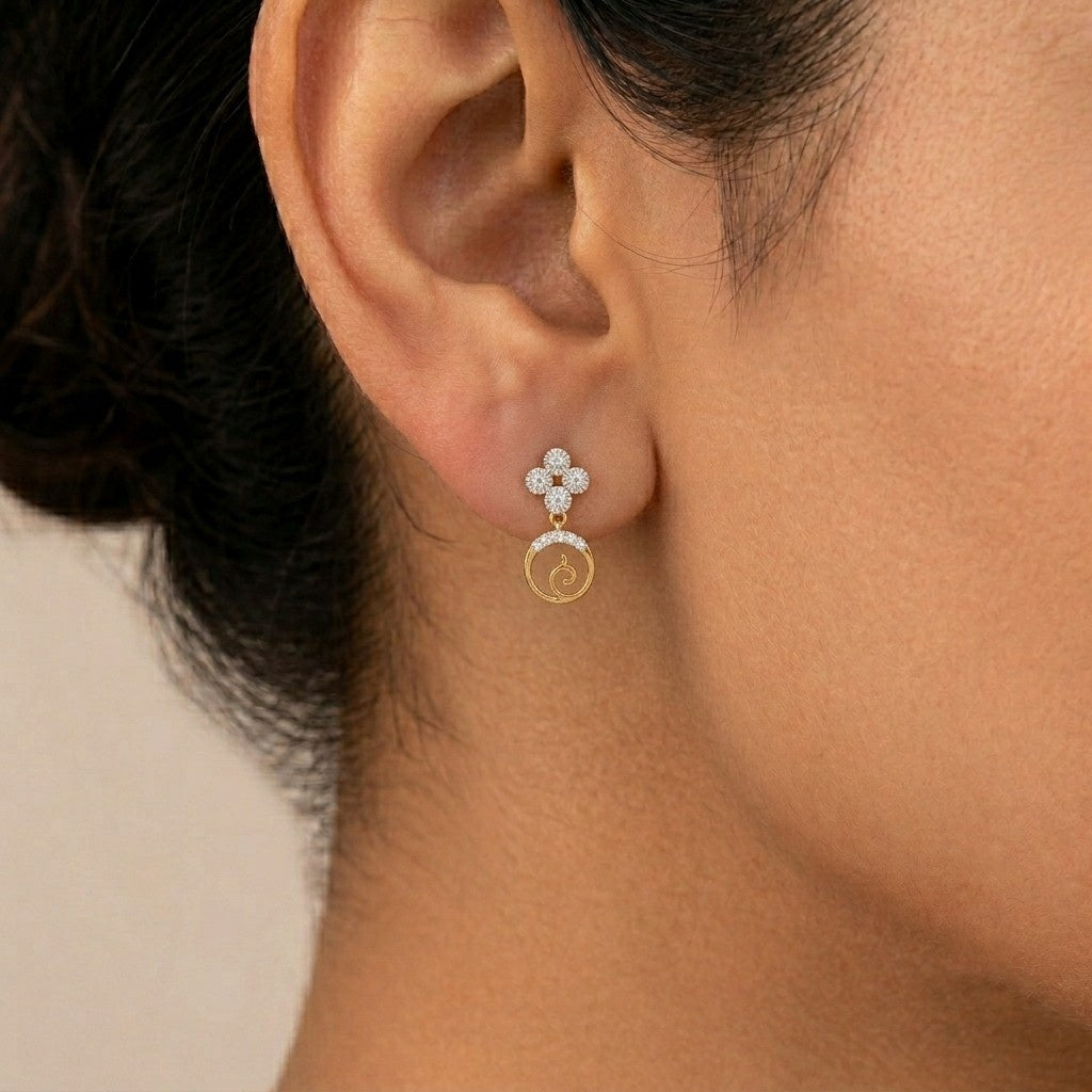 A close-up of a model's ear wearing a delicate gold and diamond earring