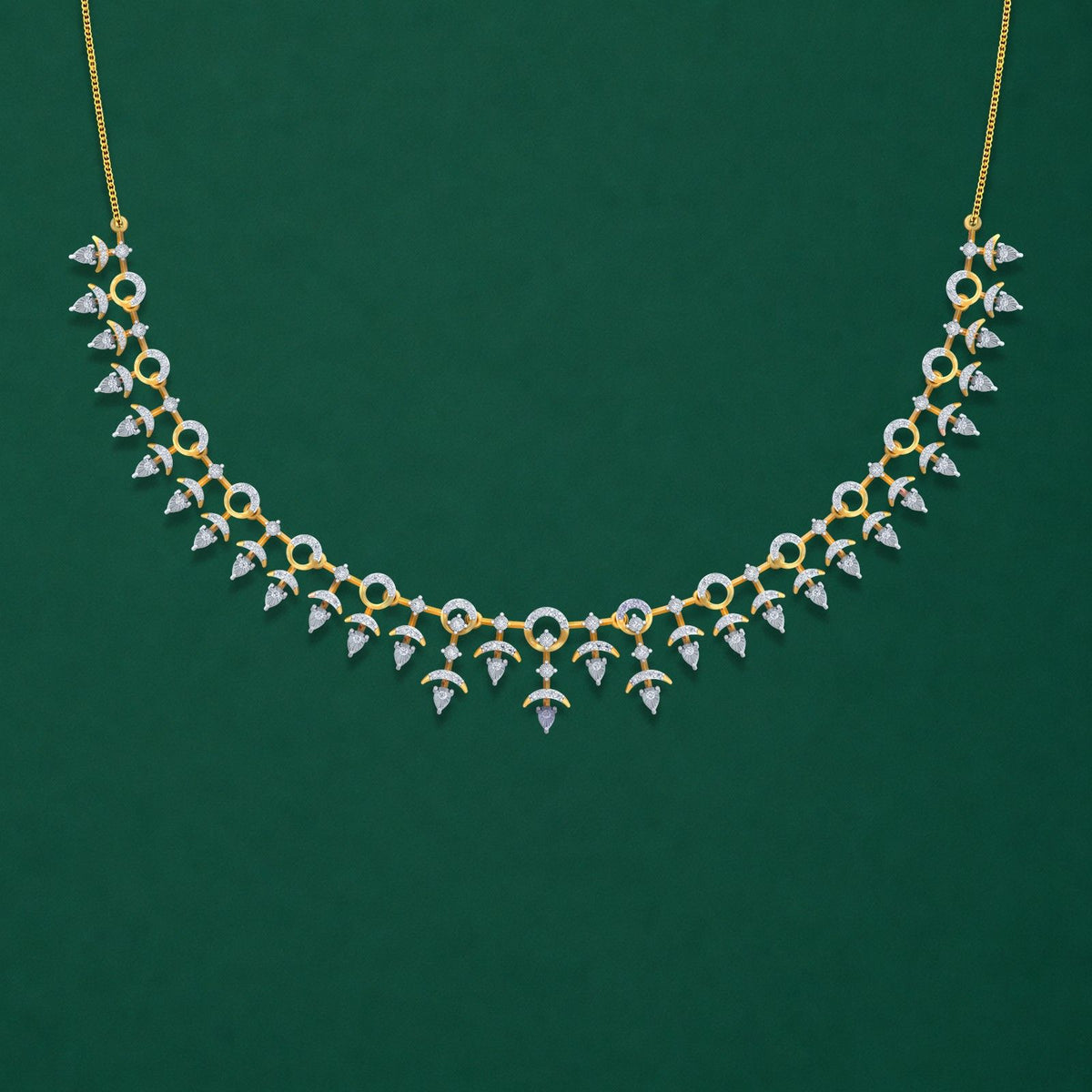 A gold and diamond necklace with a symmetrical, teardrop-shaped displayed against a solid dark green background.