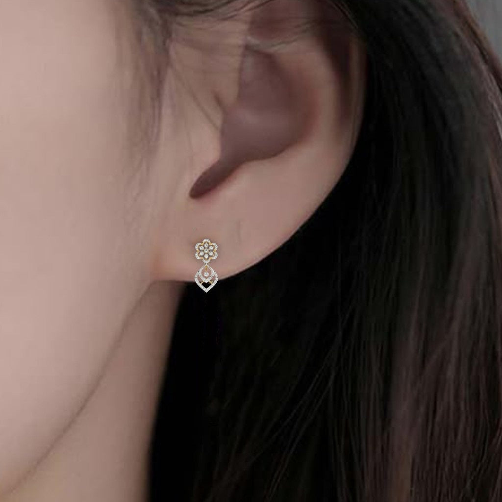 Close-up shot of a gold and diamond dangler stud earrings.