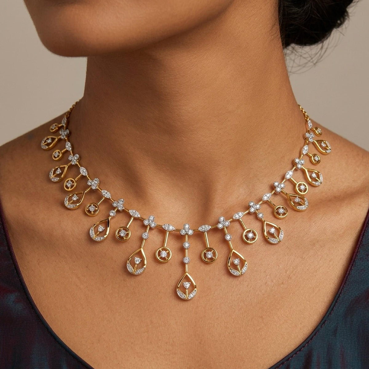 A gold and diamond necklace with teardrop-shaped drops, shown on a model's neck against a neutral beige background.
