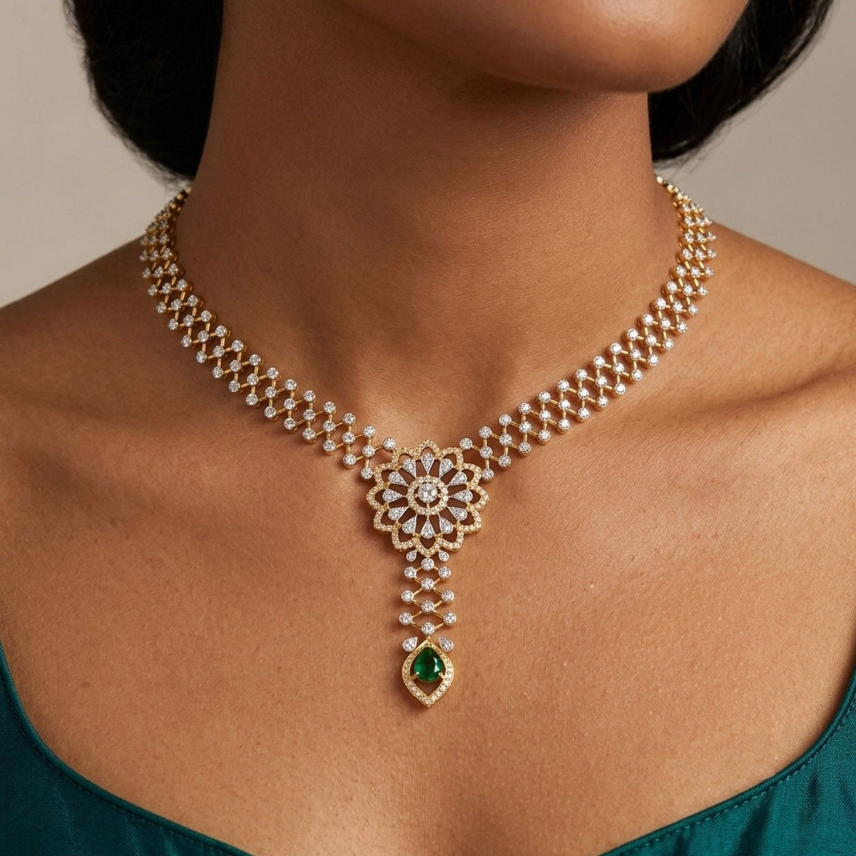 A close-up of a model wearing a gold and diamond necklace with a green teardrop gemstone.