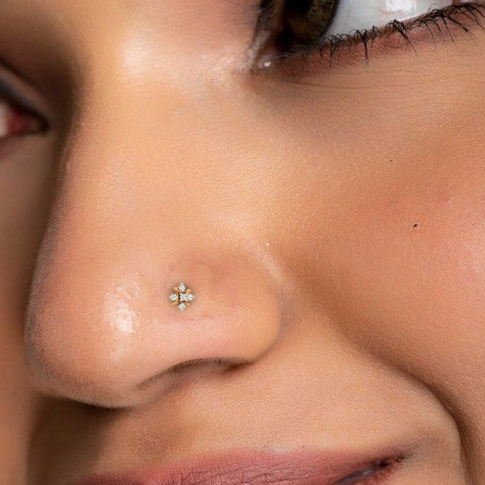 Close-up of a person wearing a small nose ring with a floral design.