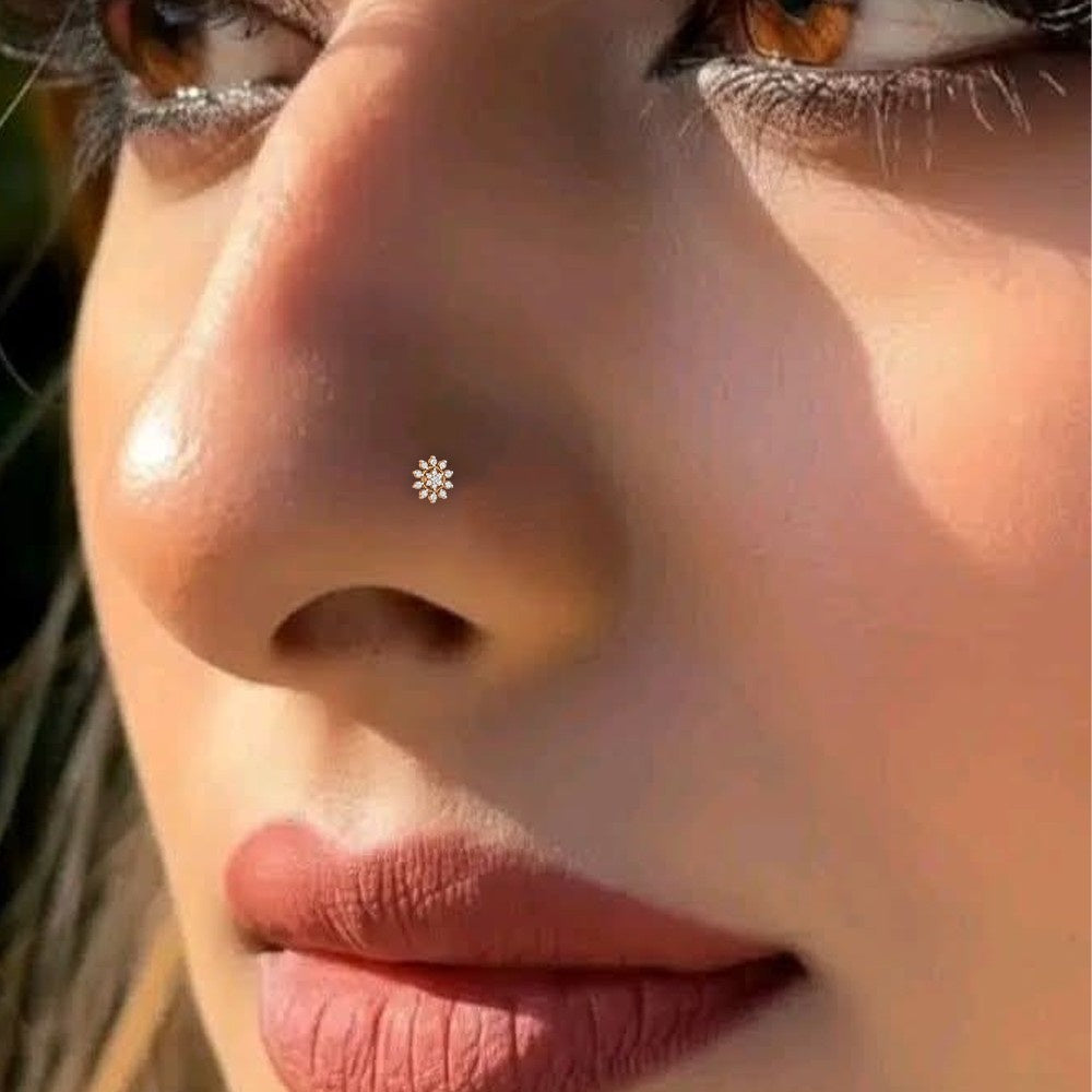 Close-up of a person's nose with a small silver flower-shaped earring.