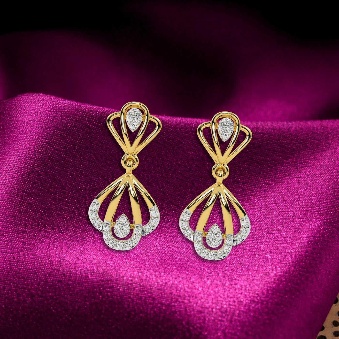 A pair of gold and diamond drop earrings featuring a fan-shaped design on a vibrant magenta background.
