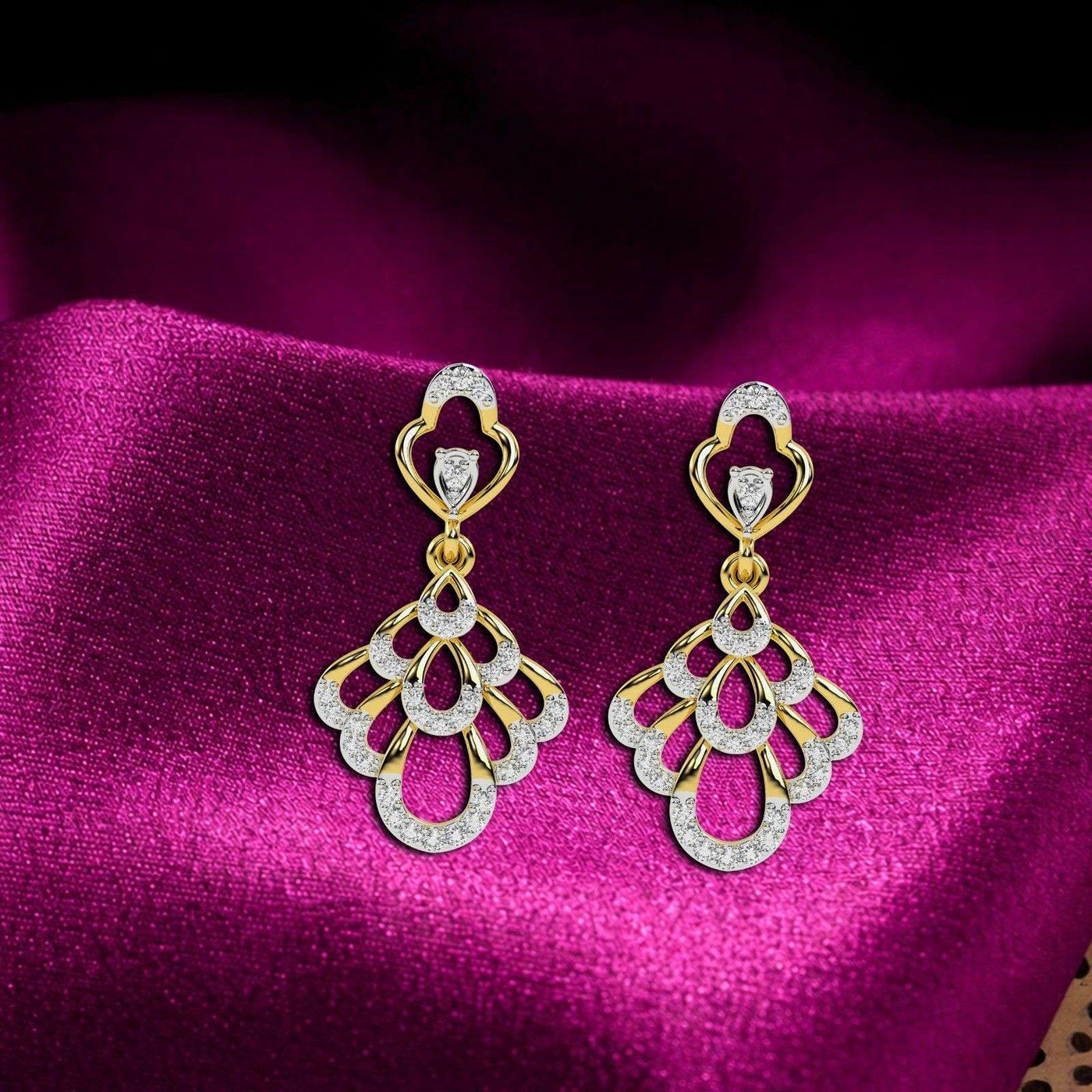 A pair of gold earrings with sparkling diamond accents on a magenta fabric  background.