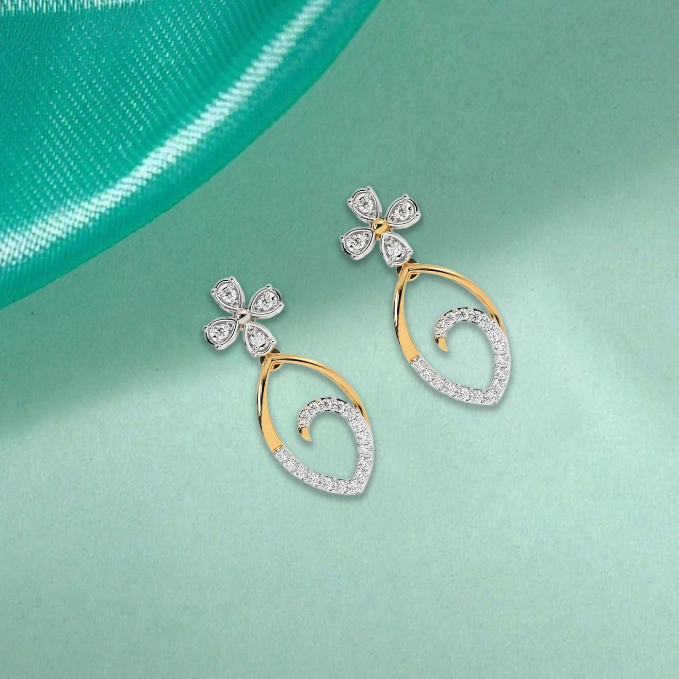 A pair of two-tone gold and diamond drop earrings featuring a floral top and an open teardrop dangle