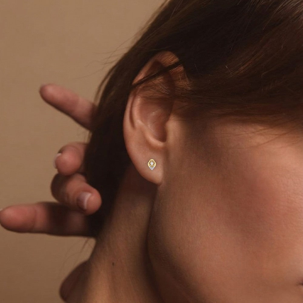 Close-up shot gold and diamond stud earring.