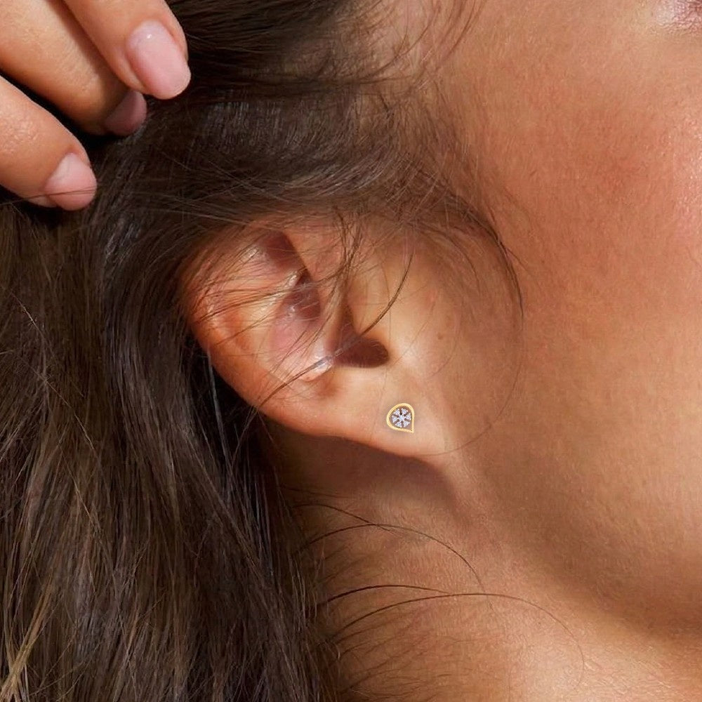 Close-up shot of a gold and diamond stud earring.