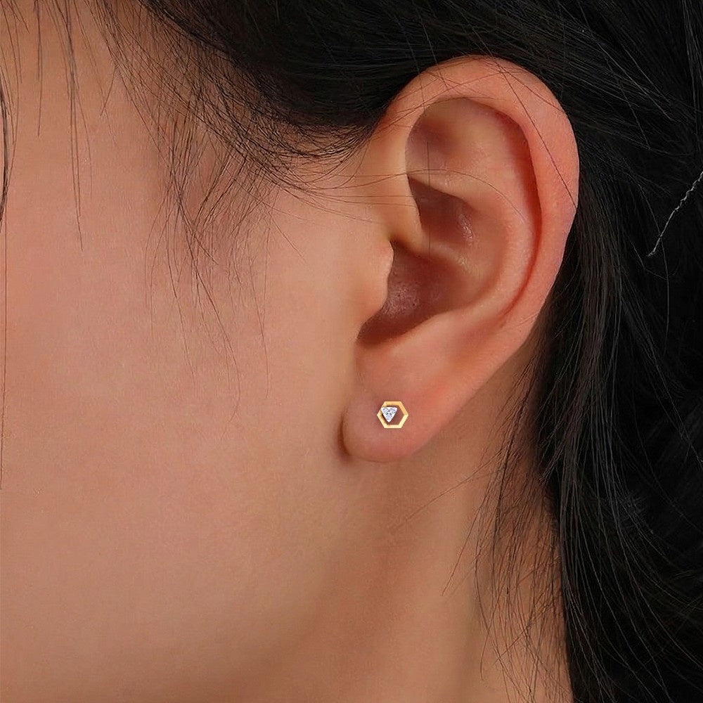 Close-up shot of a gold and diamond stud earring.