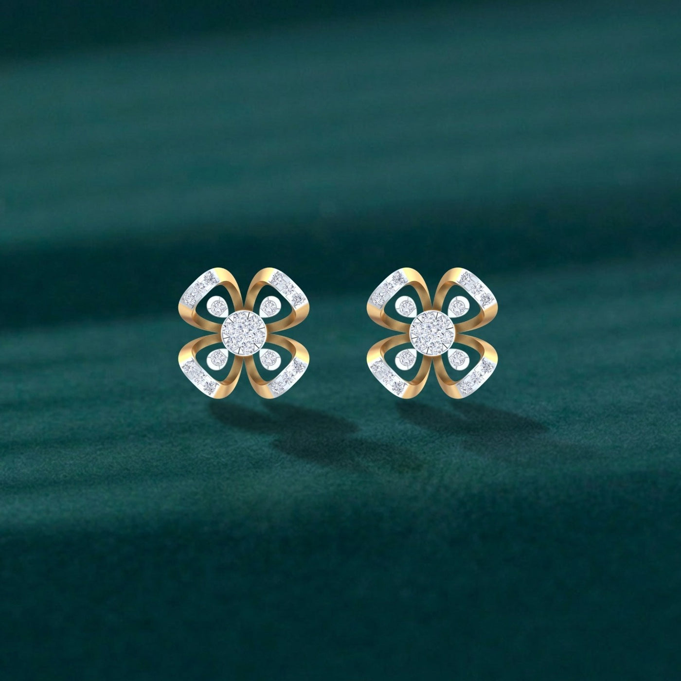 A pair of gold and diamond flower-shaped stud earrings displayed on a dark teal velvet surface.