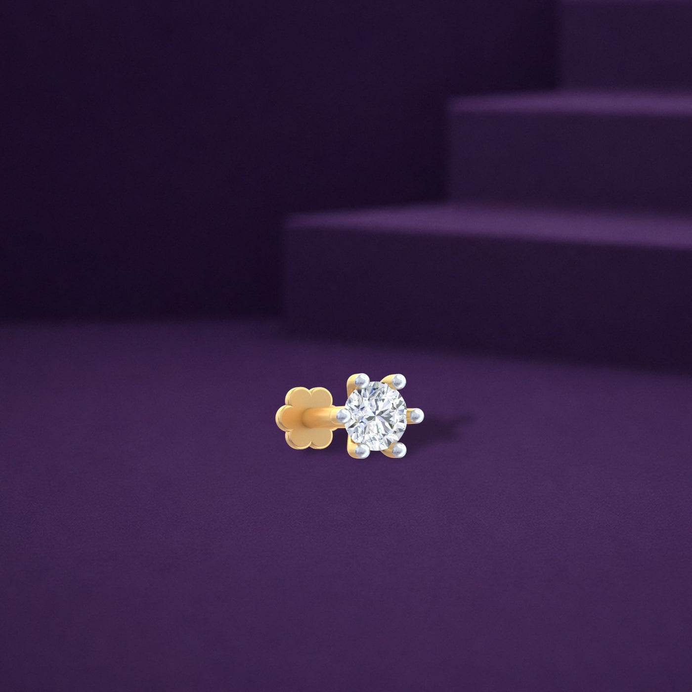 Yellow gold and diamond stud nose pin with a clear gemstone on a purple background