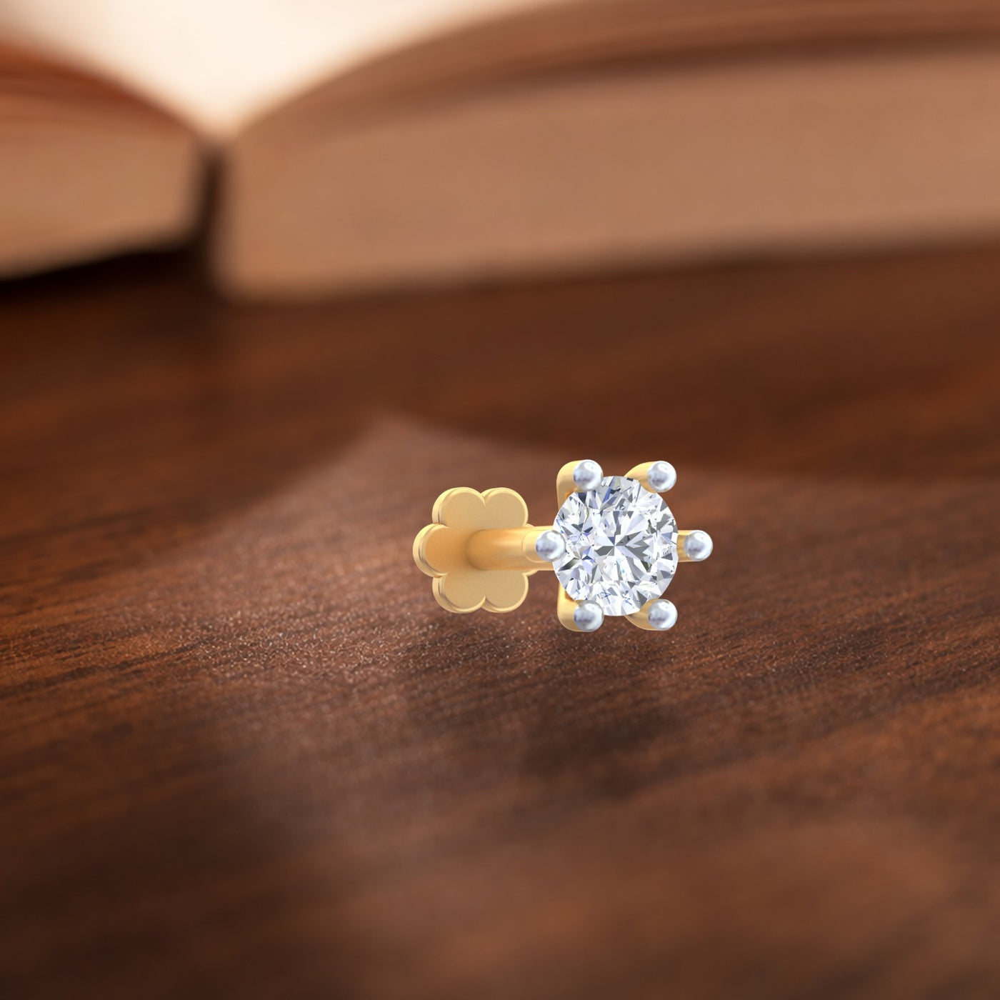 Gold and diamond stud nosepin on a wooden surface