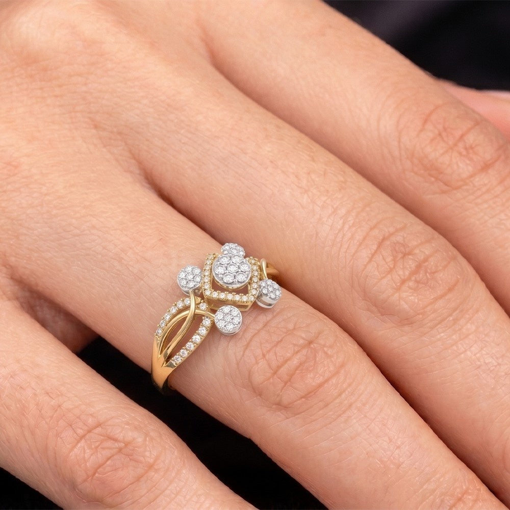 Gold and diamond ring on a person's finger against a neutral background