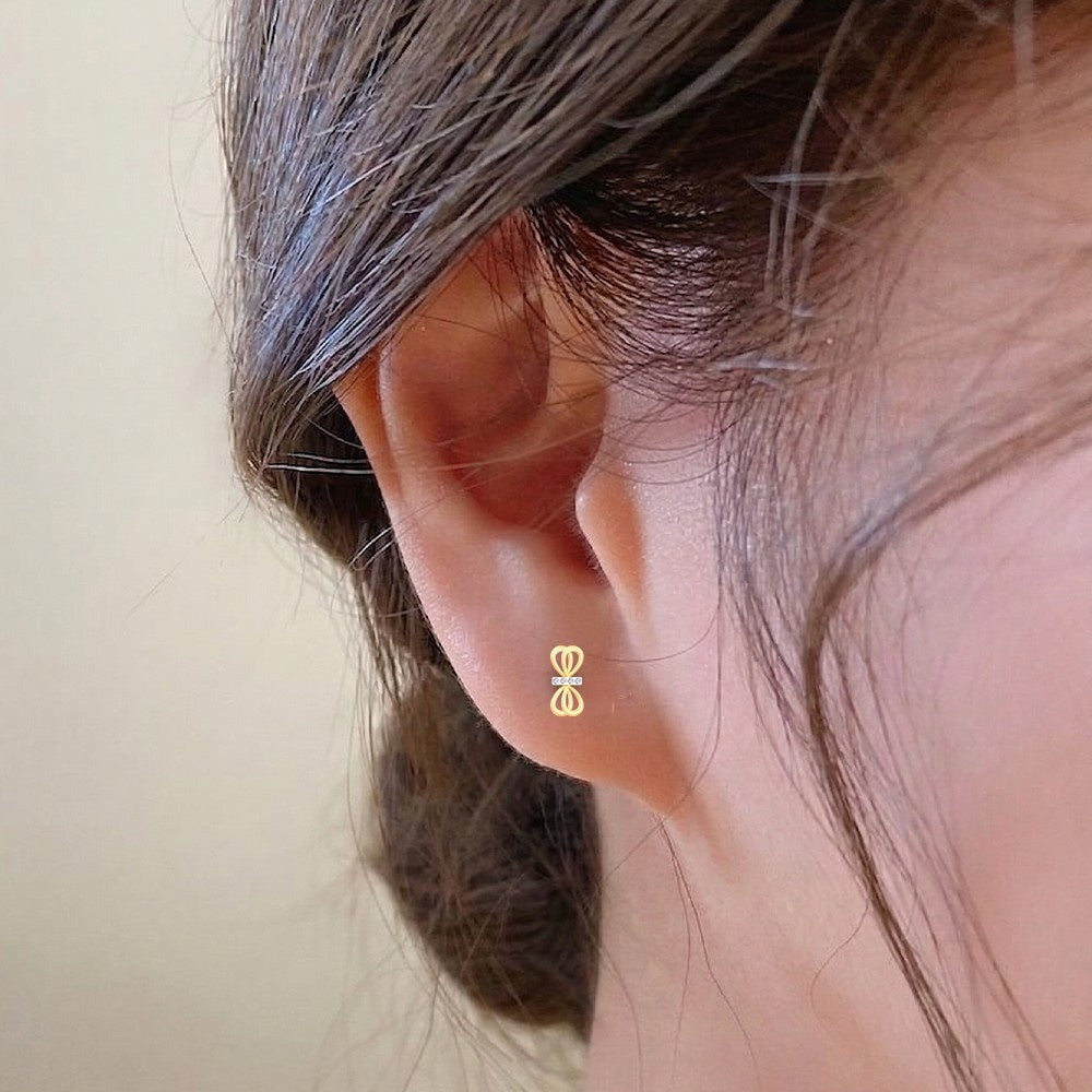 Close-up shot of a White gold and diamond bow stud earring.
