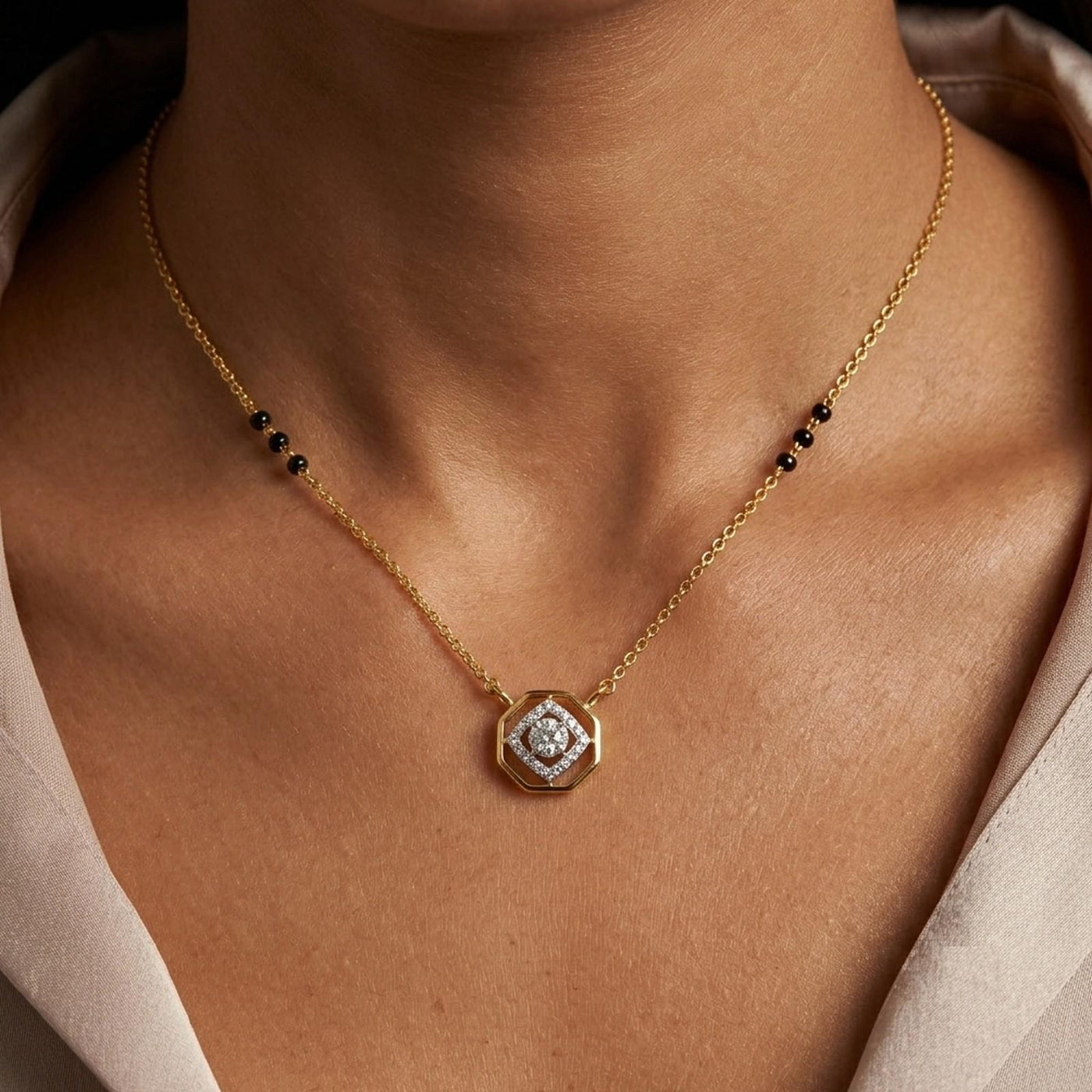 A close-up of a model's neck with a central octagonal pendant. 