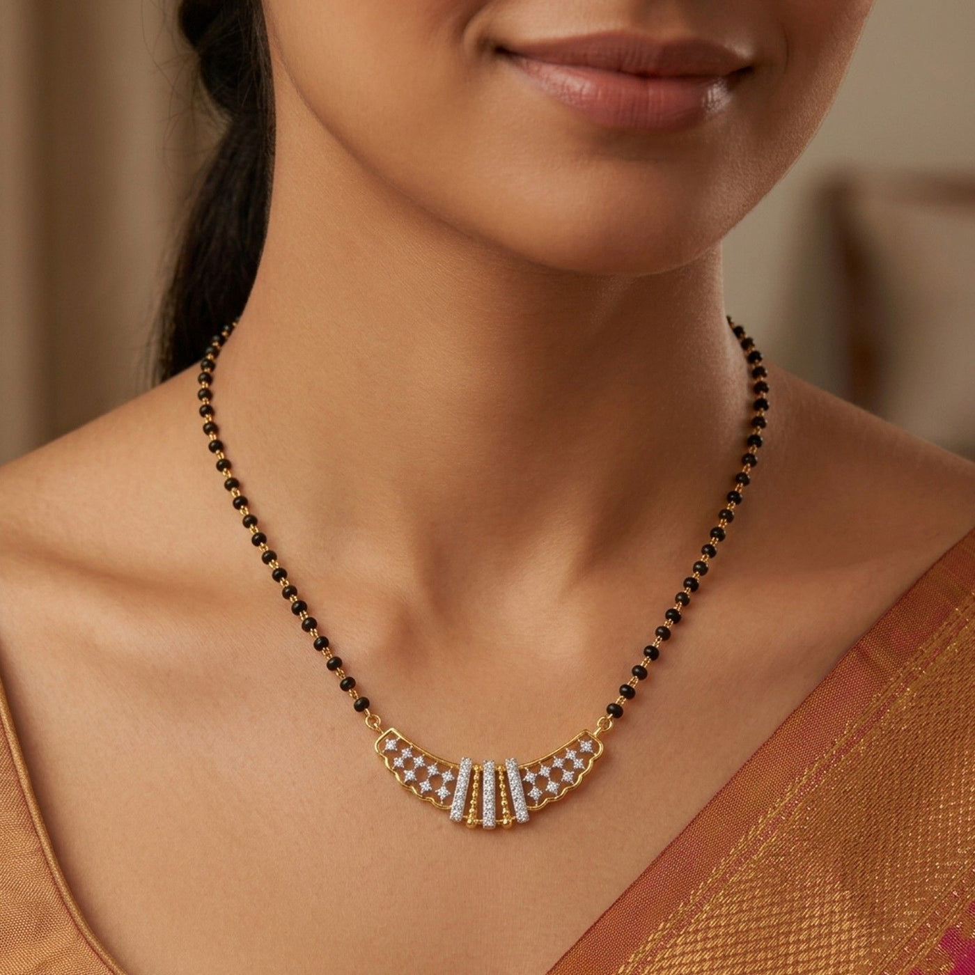 A close-up of a person wearing a single-strand black bead mangalsutra with a curved gold featuring diamond lattice work and three central vertical diamond bars