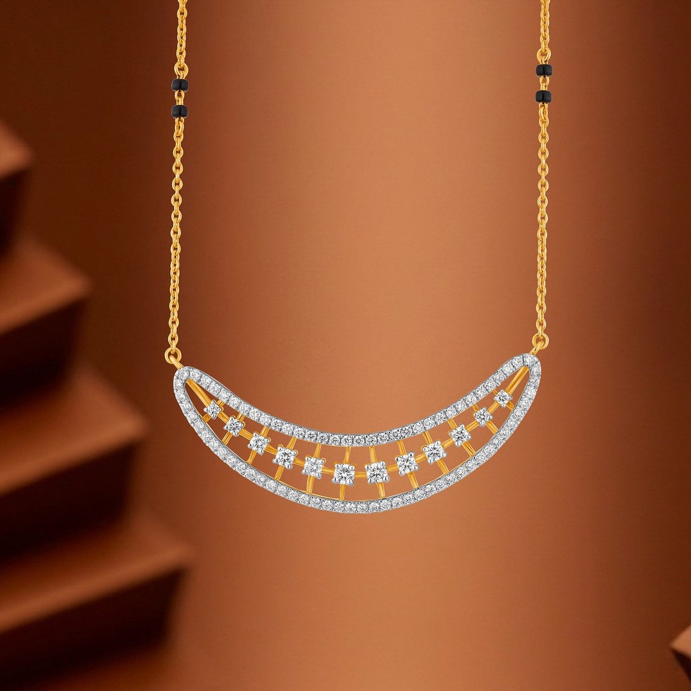 Gold crescent-shaped mangalsutra with a double-row diamond mangalsutra, suspended against a warm brown background.