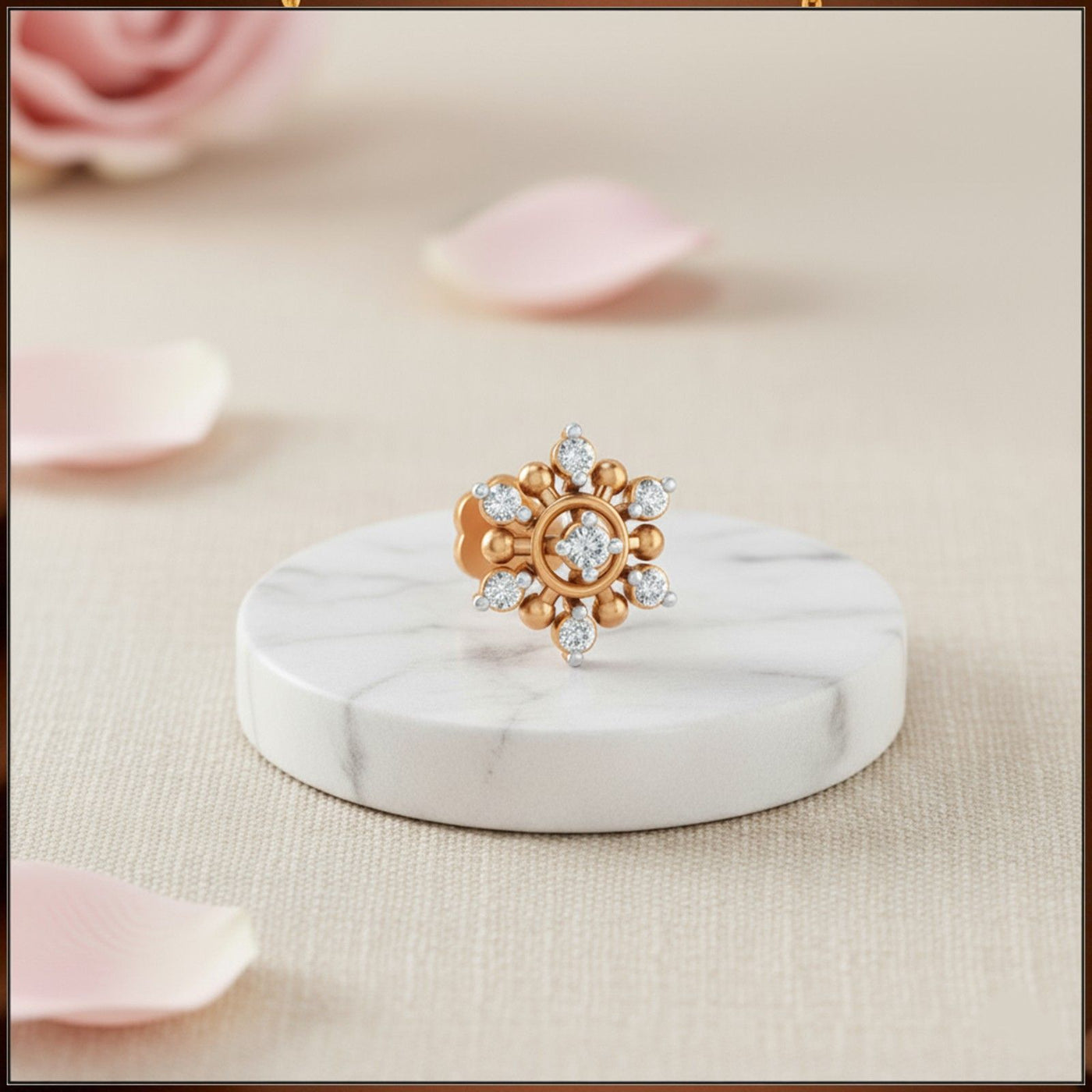 Yellow gold and diamond stud nose pin with gemstones on a marble stand with pink petals in the background