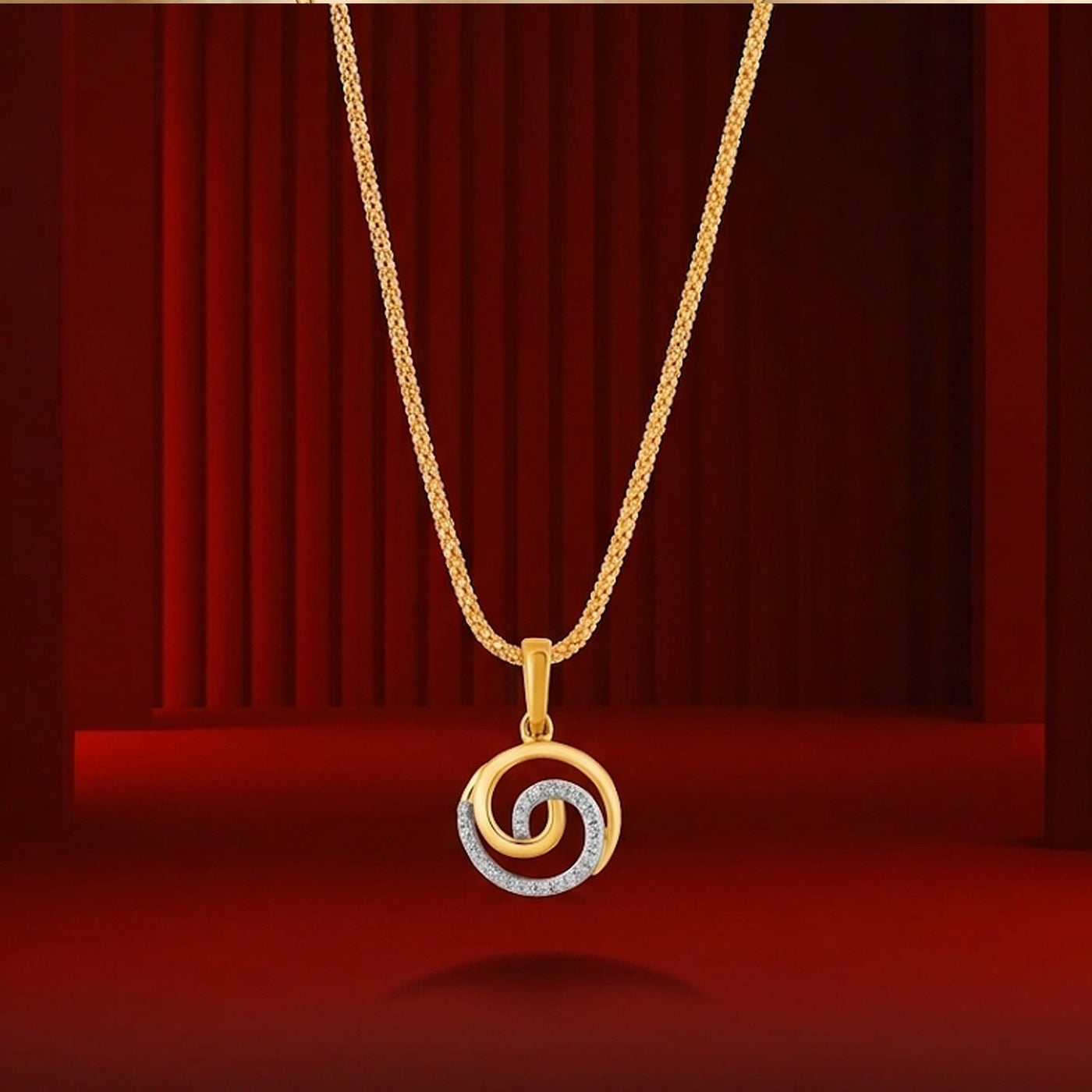 Yellow gold and diamond spiral pendant on red background