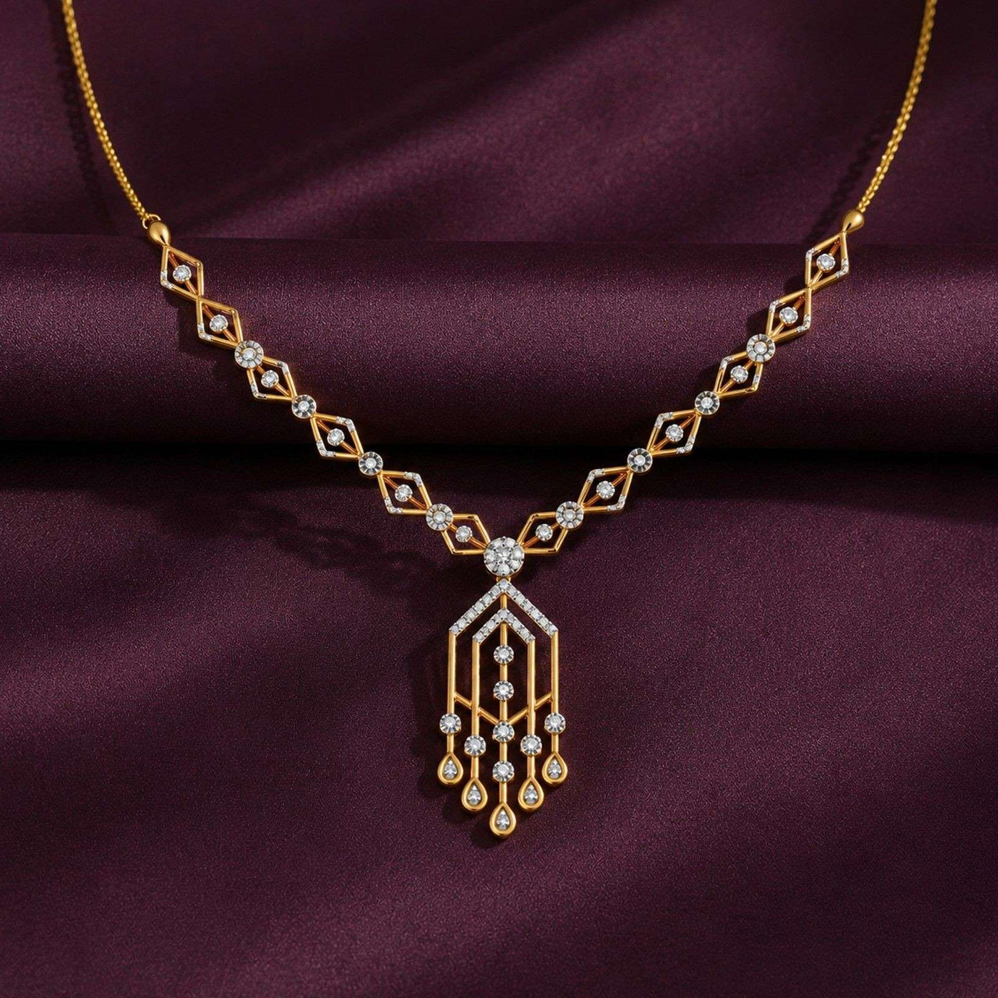 A gold style necklace with diamond accents, displayed on draped dark purple satin fabric.
