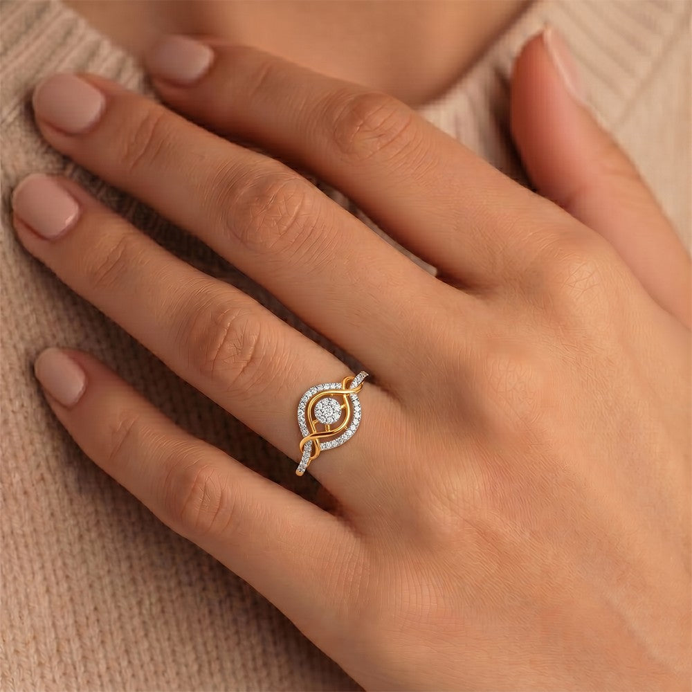 A close-up of a hand wearing a gold ring with a central clear cluster, resting against a beige knit sweater.