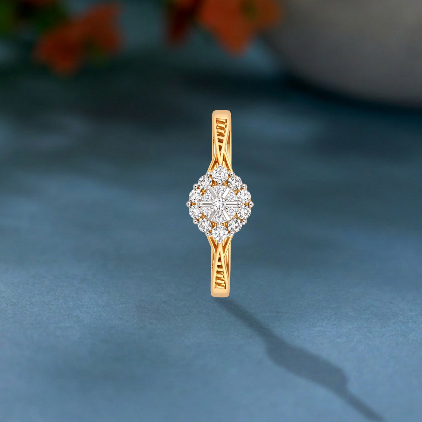 Gold and diamond ring on a teal surface.