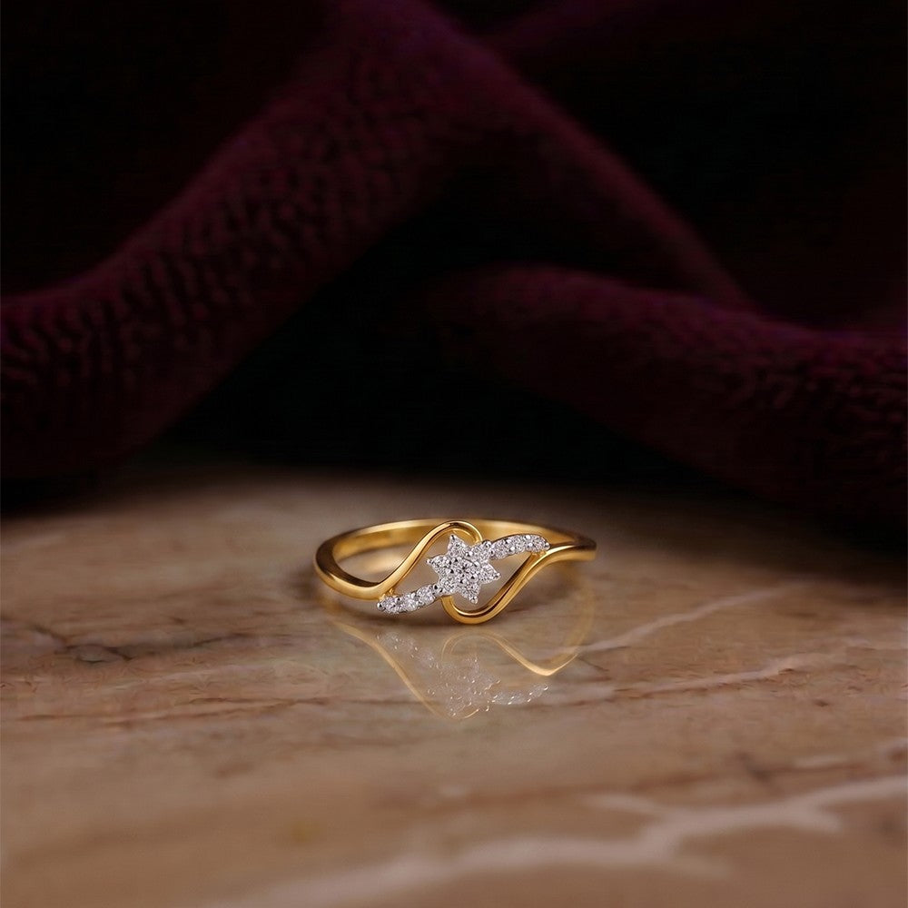 Gold and diamond with floral-design cluster setting on a reflective marble surface.