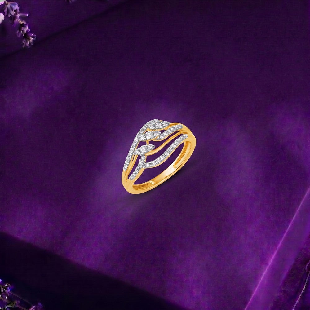 A gold and diamond split-shank ring displayed on a textured purple velvet surface.