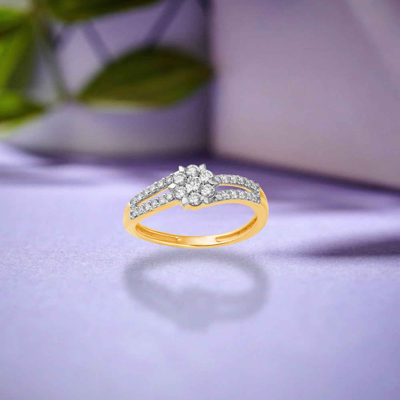 Gold ring with a diamond cluster centerpiece, shown on a purple surface.