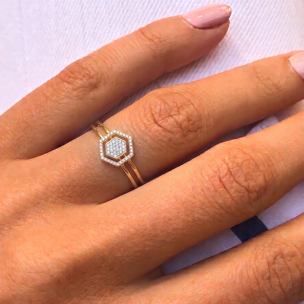 Gold and diamond with Hexagon-shaped cluster setting on a person's finger.
