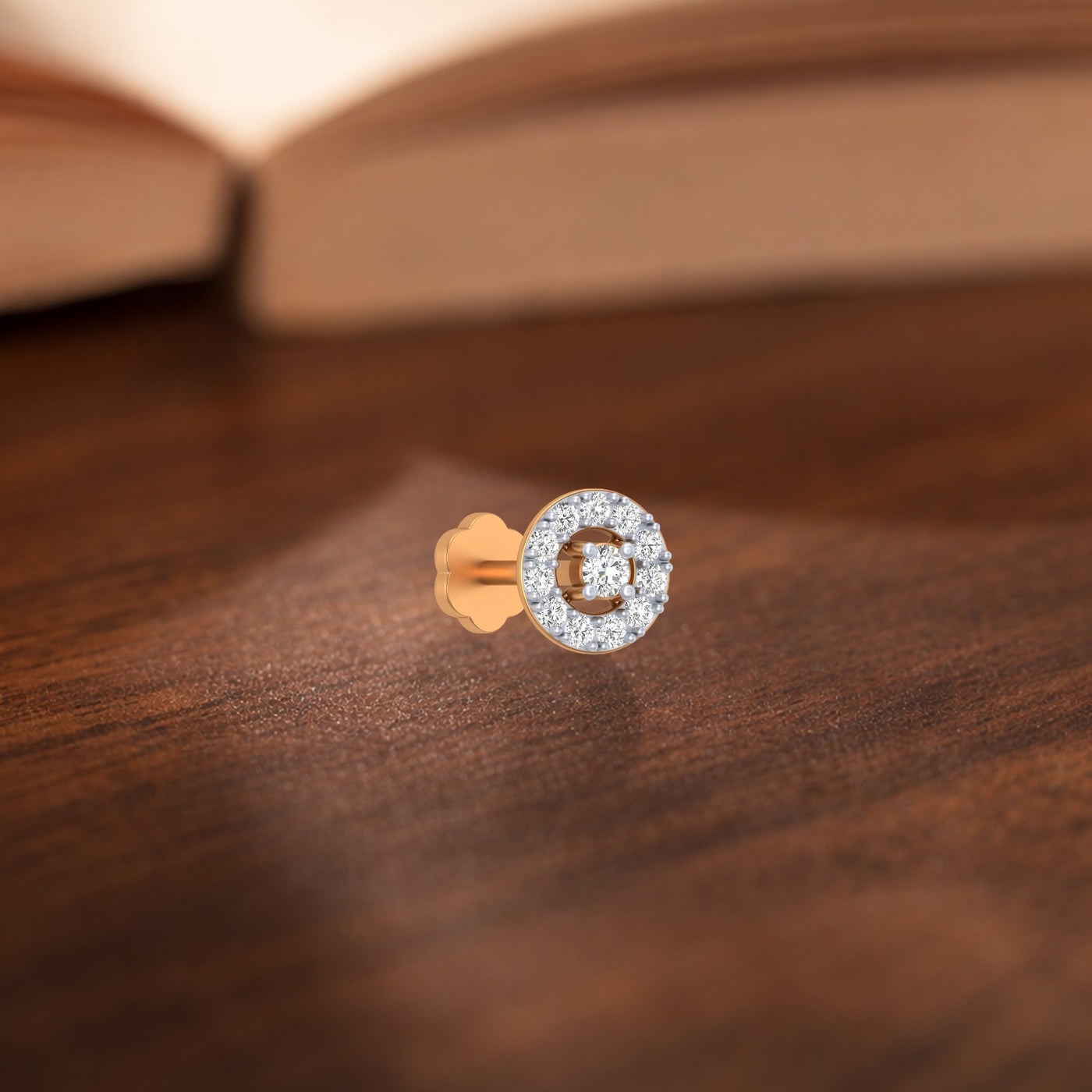 yellow gold and diamond stud nose pin on a wooden surface