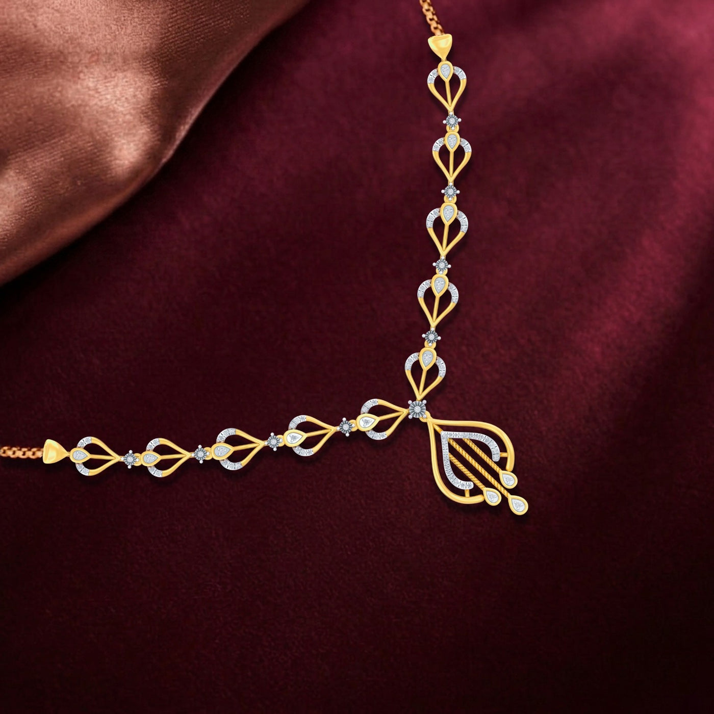 Gold and diamond necklace on a maroon fabric background