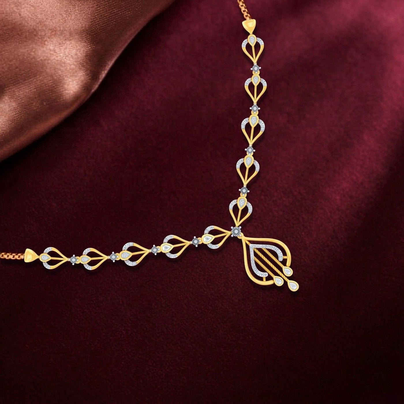 Gold and silver necklace on a maroon fabric background