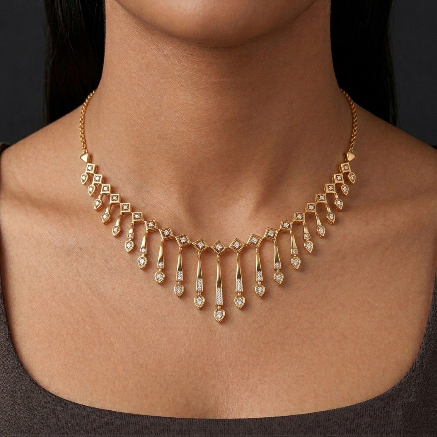 Gold necklace with diamonds on a person against a dark background