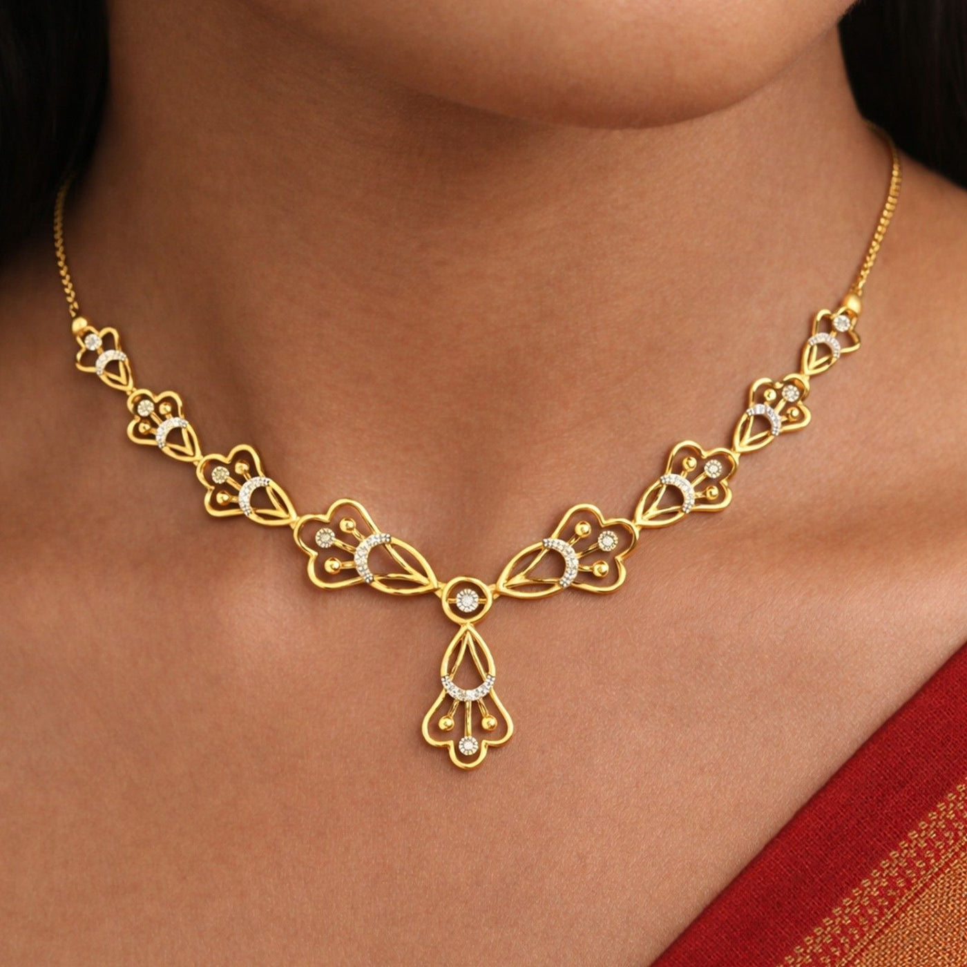 A gold and diamond necklace with floral design, shown worn on a model's neck.