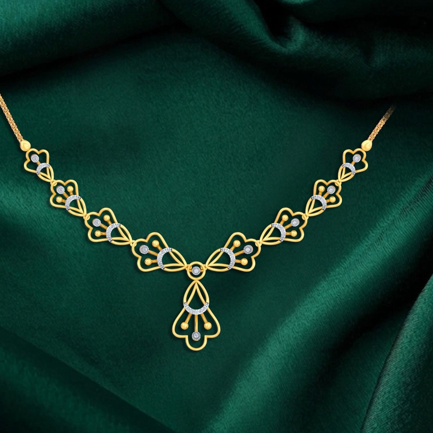 A gold and diamond necklace, displayed on a draped dark green satin fabric.
