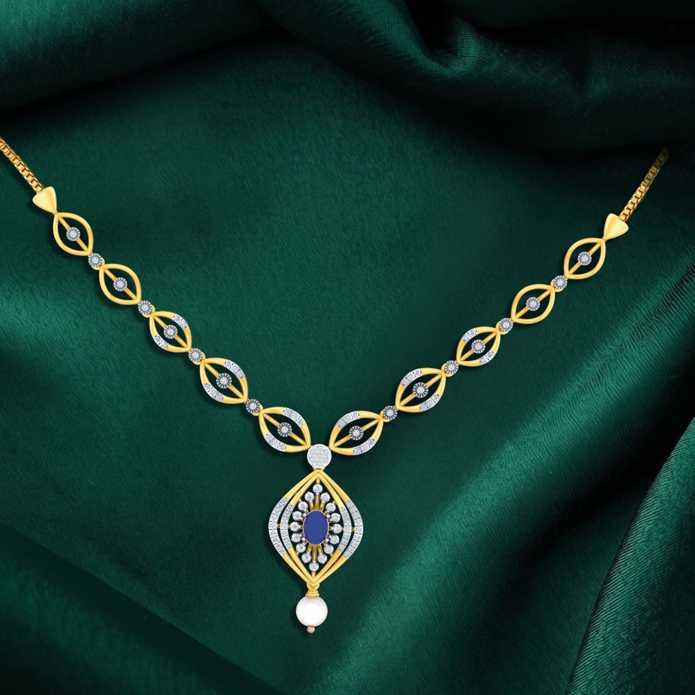 Gold and diamond necklace with a sapphire gemstone on a green fabric background