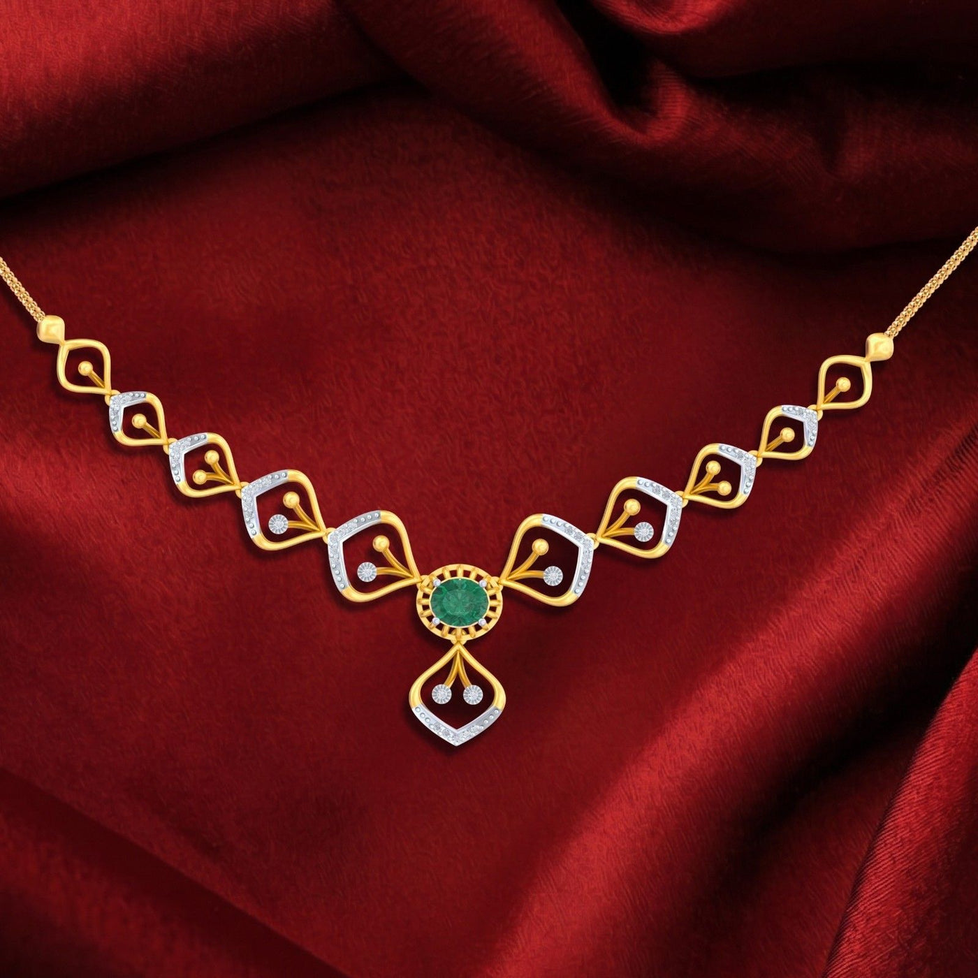 Gold necklace with a green gemstone on a red fabric background.