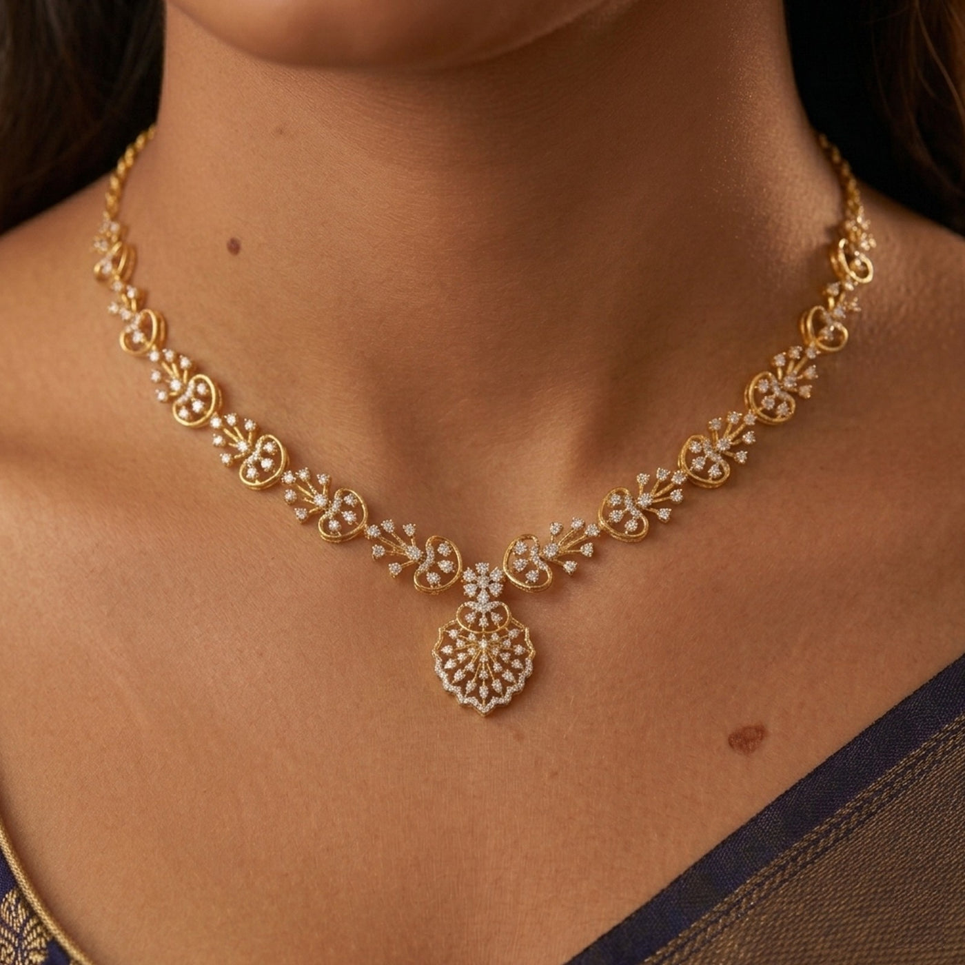 Gold necklace with floral design on a person's neck